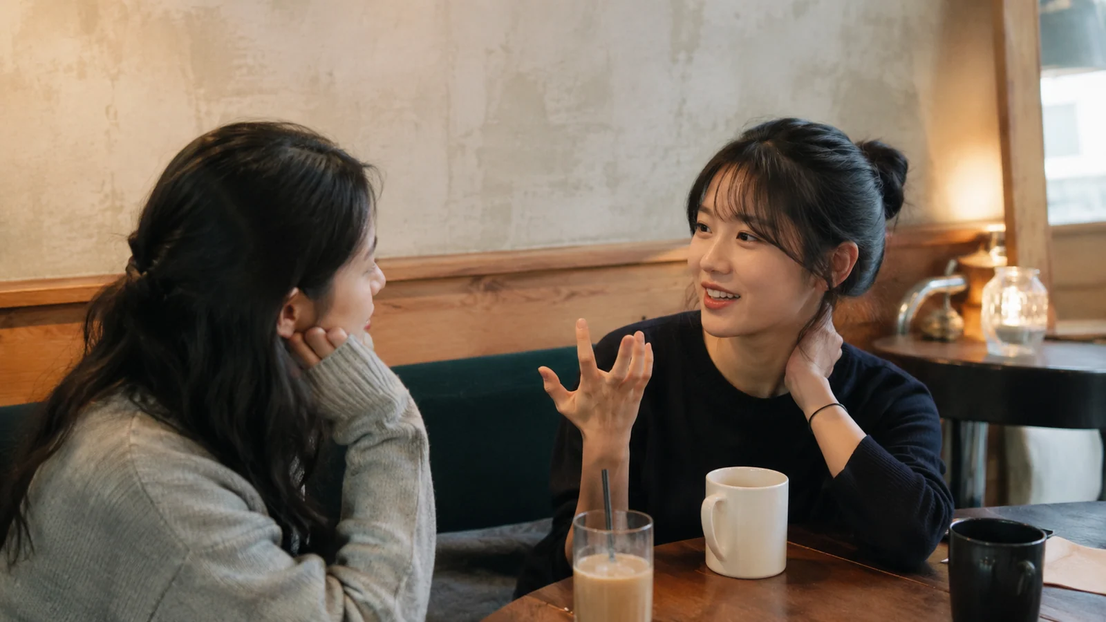 카페에서 마주 앉아 서로의 첫인상을 이야기하는 두 친구