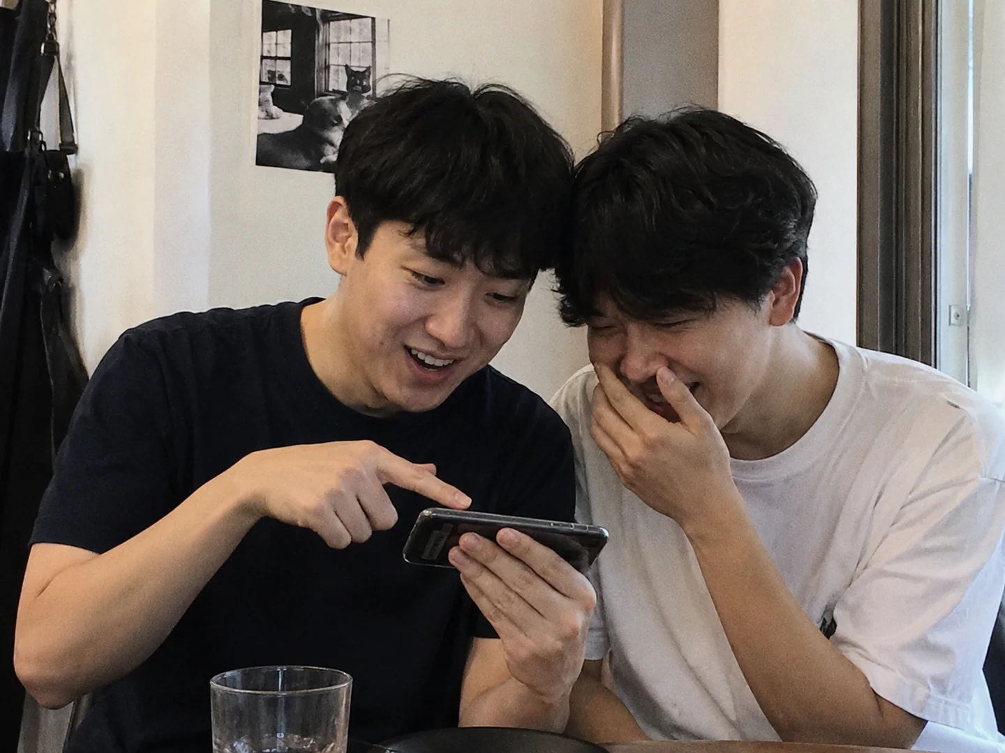 친구 둘이 스마트폰 퀴즈를 보며 자신 있게 고른 오답에 함께 웃는 모습